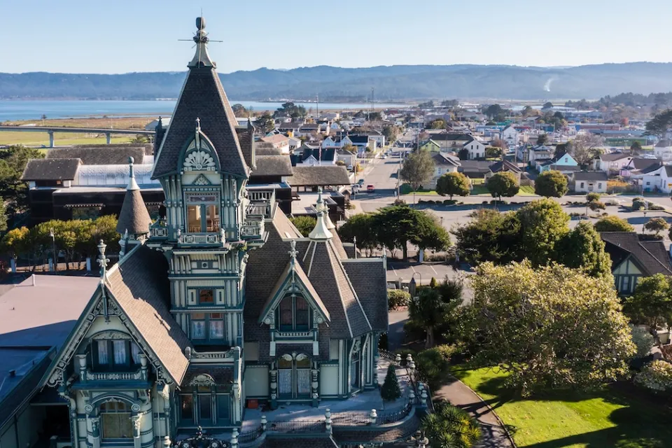 Ornate Victorian home in foreground and neighborhood in Eureka, California.